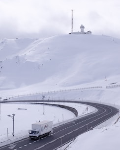 wide road with truck traveling under white sky