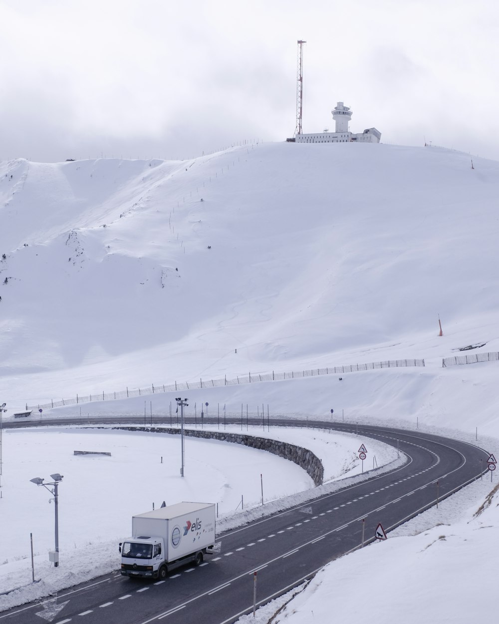 strada larga con camion che viaggia sotto il cielo bianco