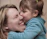 woman carrying girl while toddler kissing her nose
