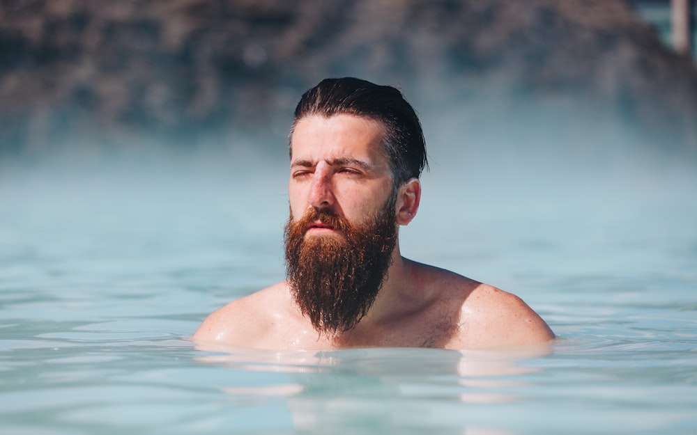 man dipping in body of water