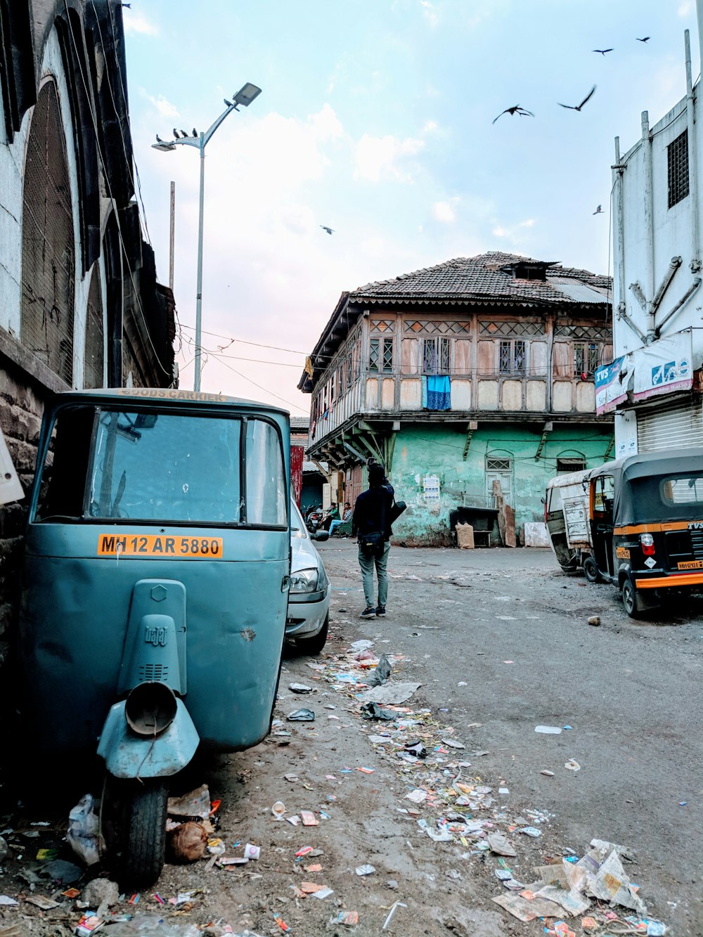 gray autorickshaw parked beside footpath road