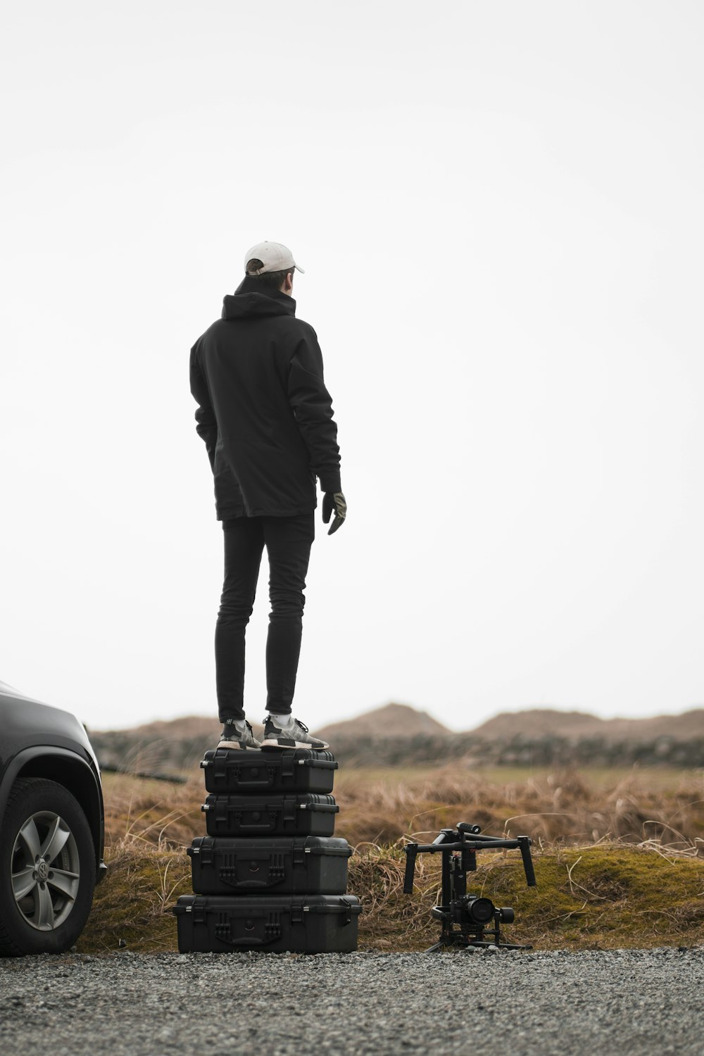 man standing on four filed suitcases during daytime