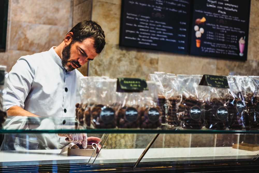 man holding box on top of display counter