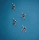 four airplane under clear blue sky during daytime