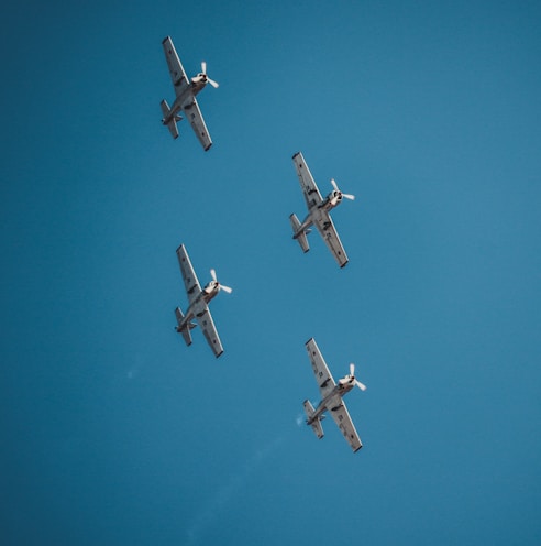 four airplane under clear blue sky during daytime