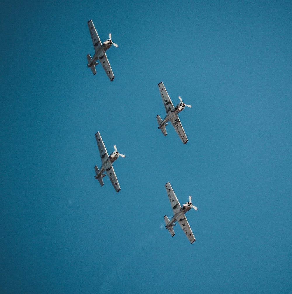 Cuatro aviones bajo un cielo azul claro durante el día