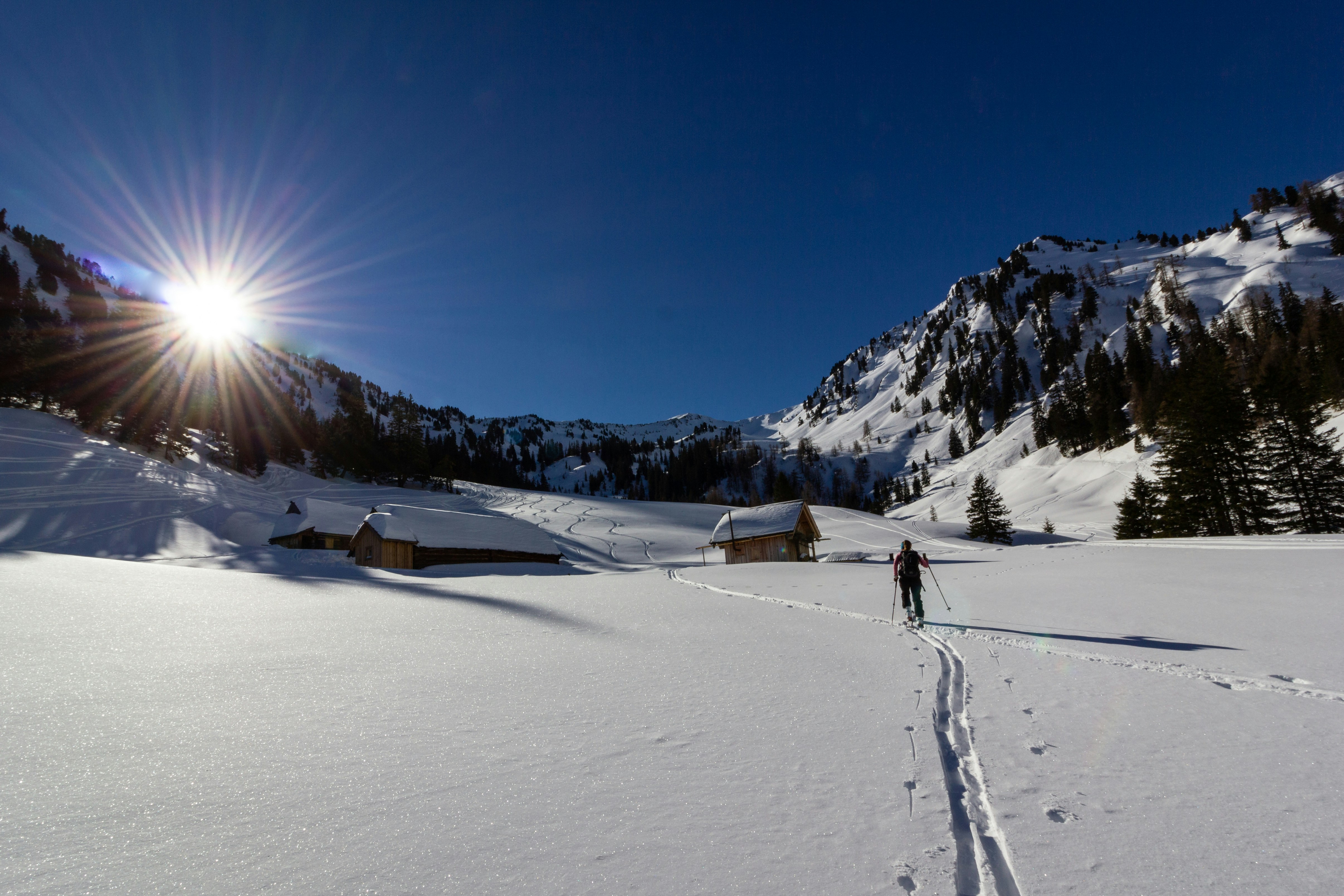 man holding ski poles near mountains