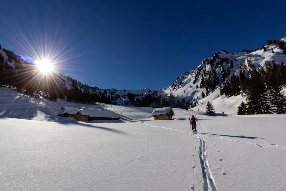 uomo che tiene i bastoncini da sci vicino alle montagne