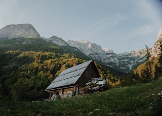 brown wooden house near mountain during daytime