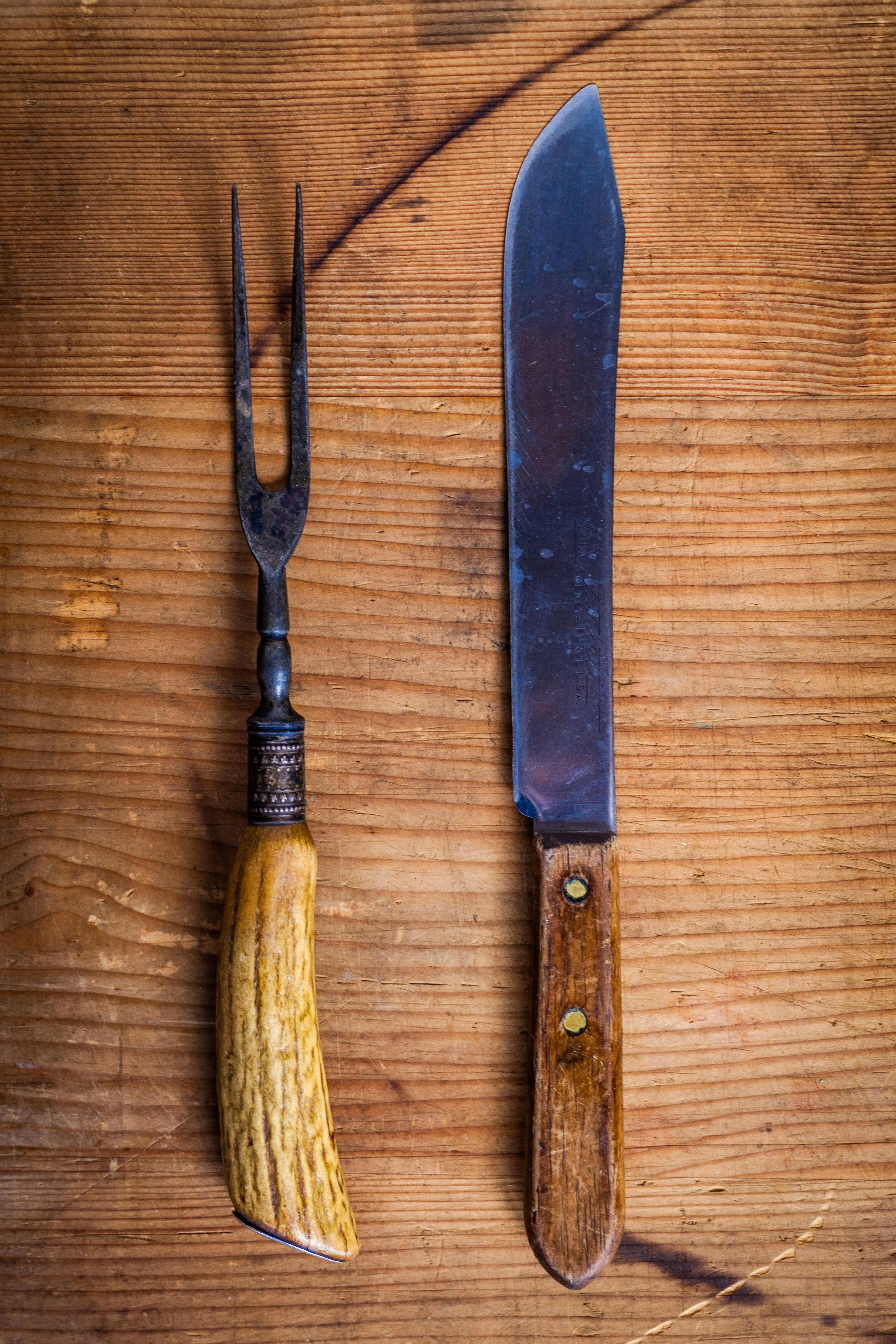 Vintage carving knife and fork set with antler handles on dark wood