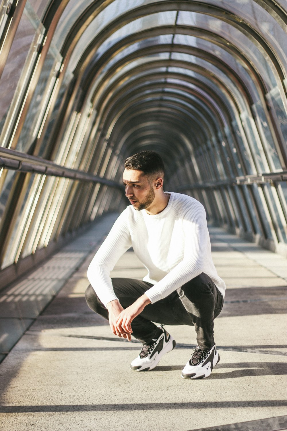 man crouching inside white building