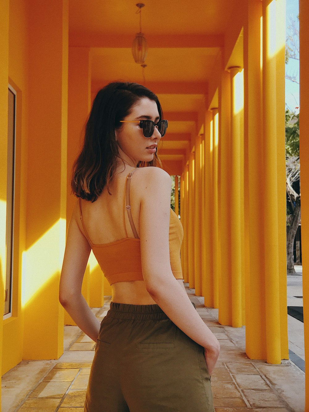 woman standing under yellow painted building