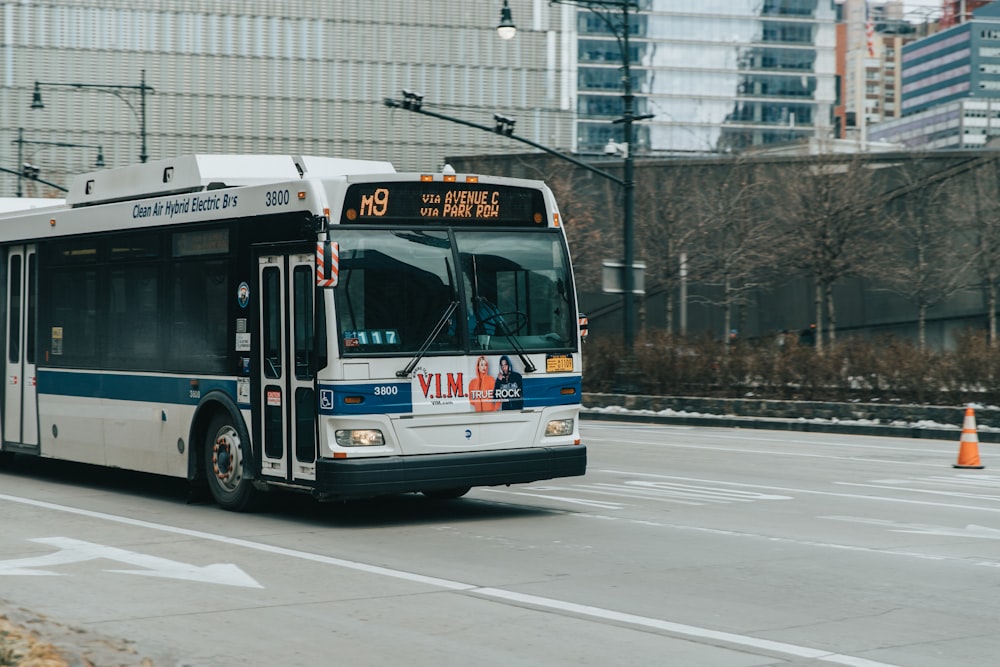 white and blue bus on road at daytime