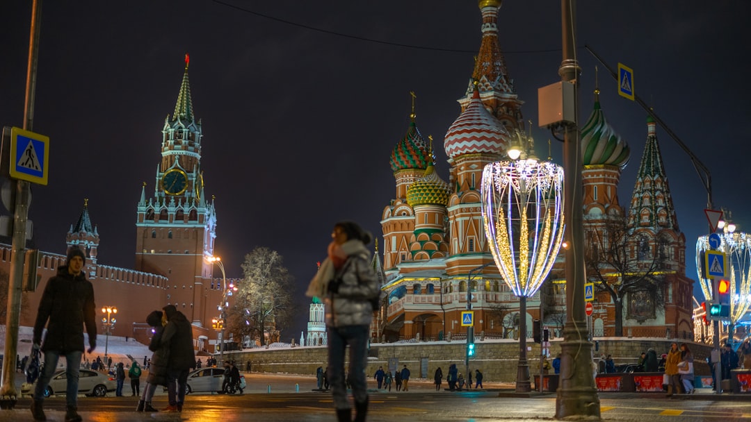 man standing beside Saint Basil's Cathedral