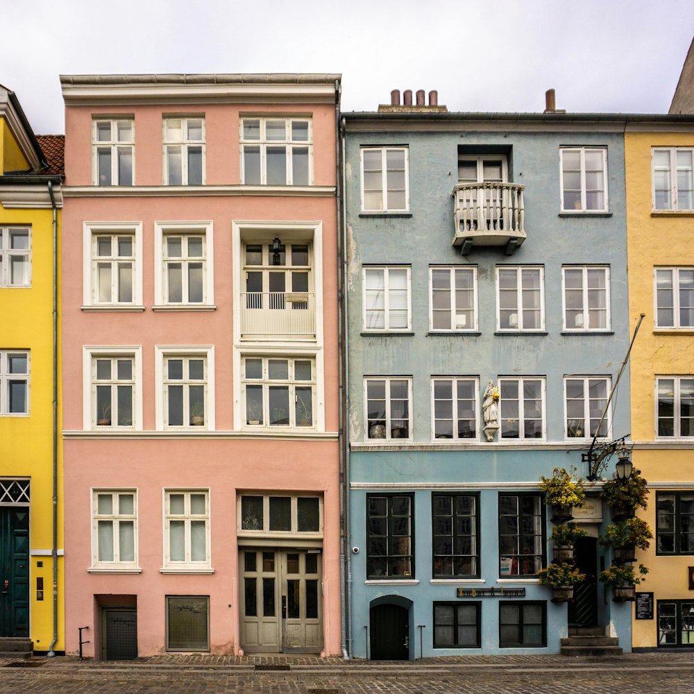 pink 5-storey house near blue 5-storey house