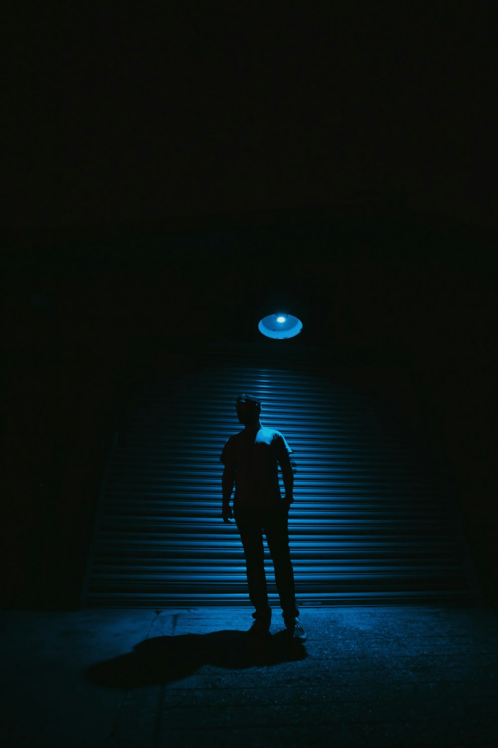 person standing near roll-up door with light turned-on