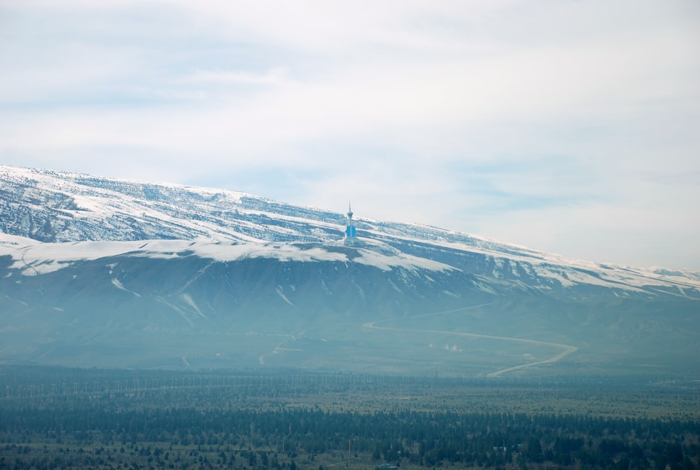 Torre branca e azul no topo da montanha coberta de neve