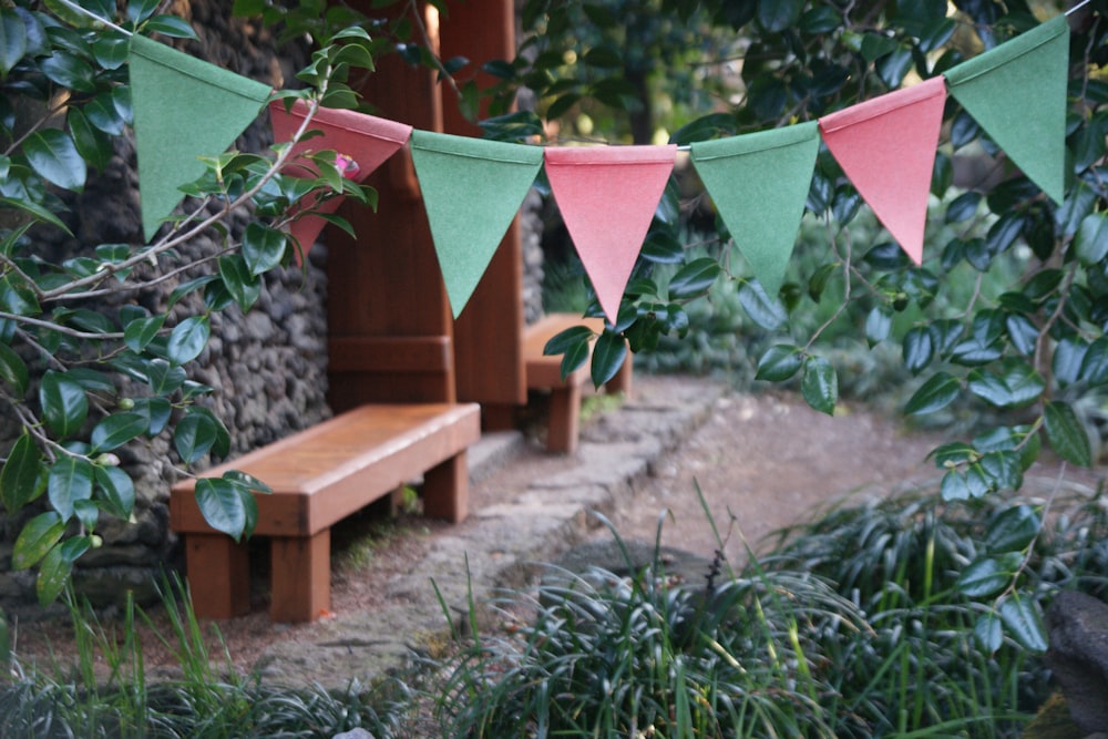 brown concrete bench with green and pink buntings during daytime