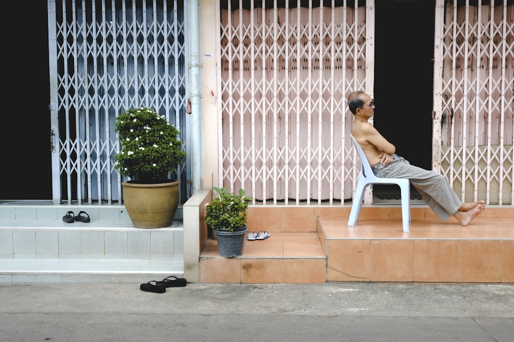 man sitting on monobloc armchair