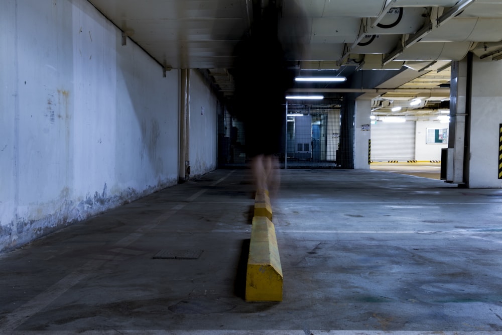 a blurry image of a person walking in a parking garage
