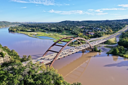 cars passing by bridge during daytime
