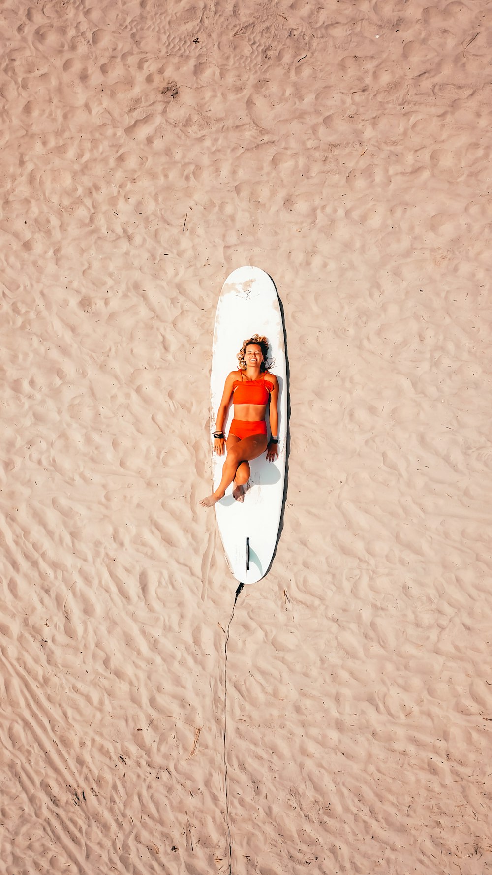 Mujer acostada en la tabla de surf