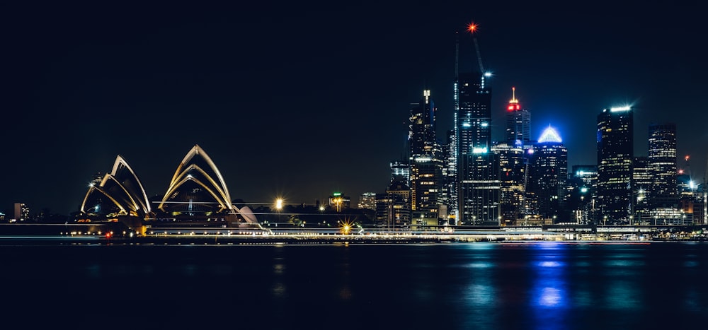 a city skyline at night with lights reflecting in the water