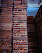 Fresh crates of assorted fruits ready for wholesale distribution in a bustling warehouse.