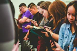 standing people all using smartphones