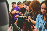 standing people all using smartphones