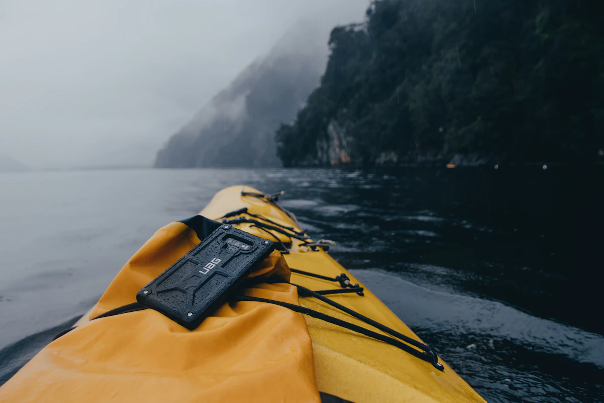 Yellow kayak on calm water with a dry bag strapped on deck