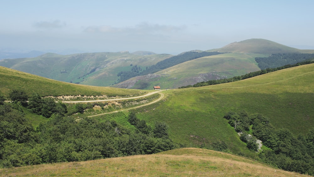 grass filed covered mountains during daytime