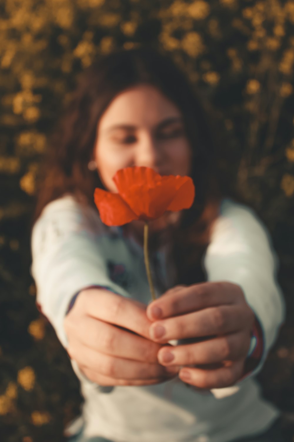 donna che tiene il fiore dai petali d'arancio