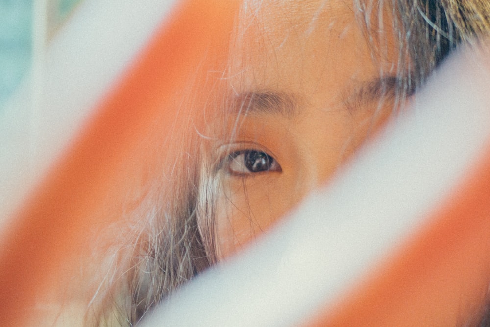 woman covering camera with hand with view of right eye