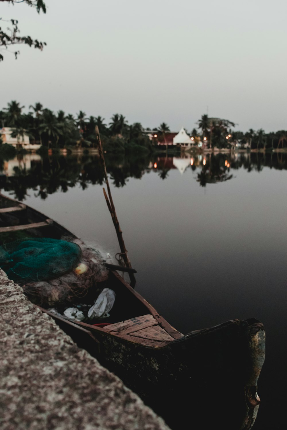 brown wooden boat at dock on calm body of water