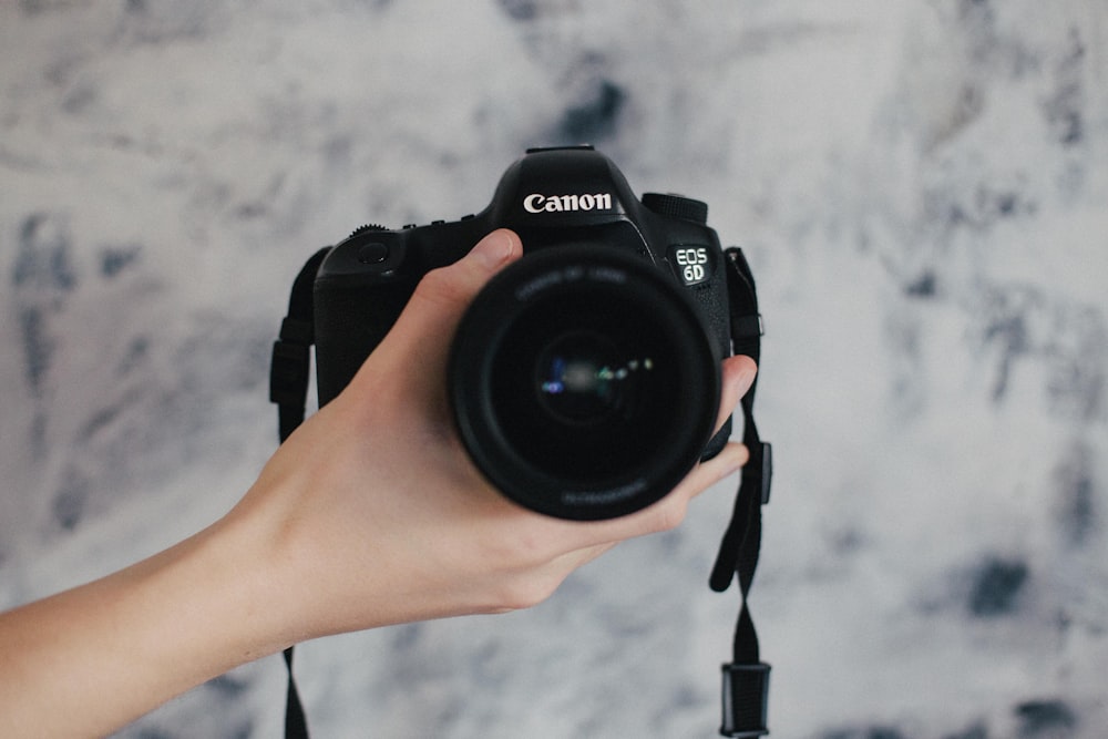 person holding black Canon EOS 6D