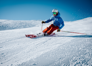 man ice skiing on hill