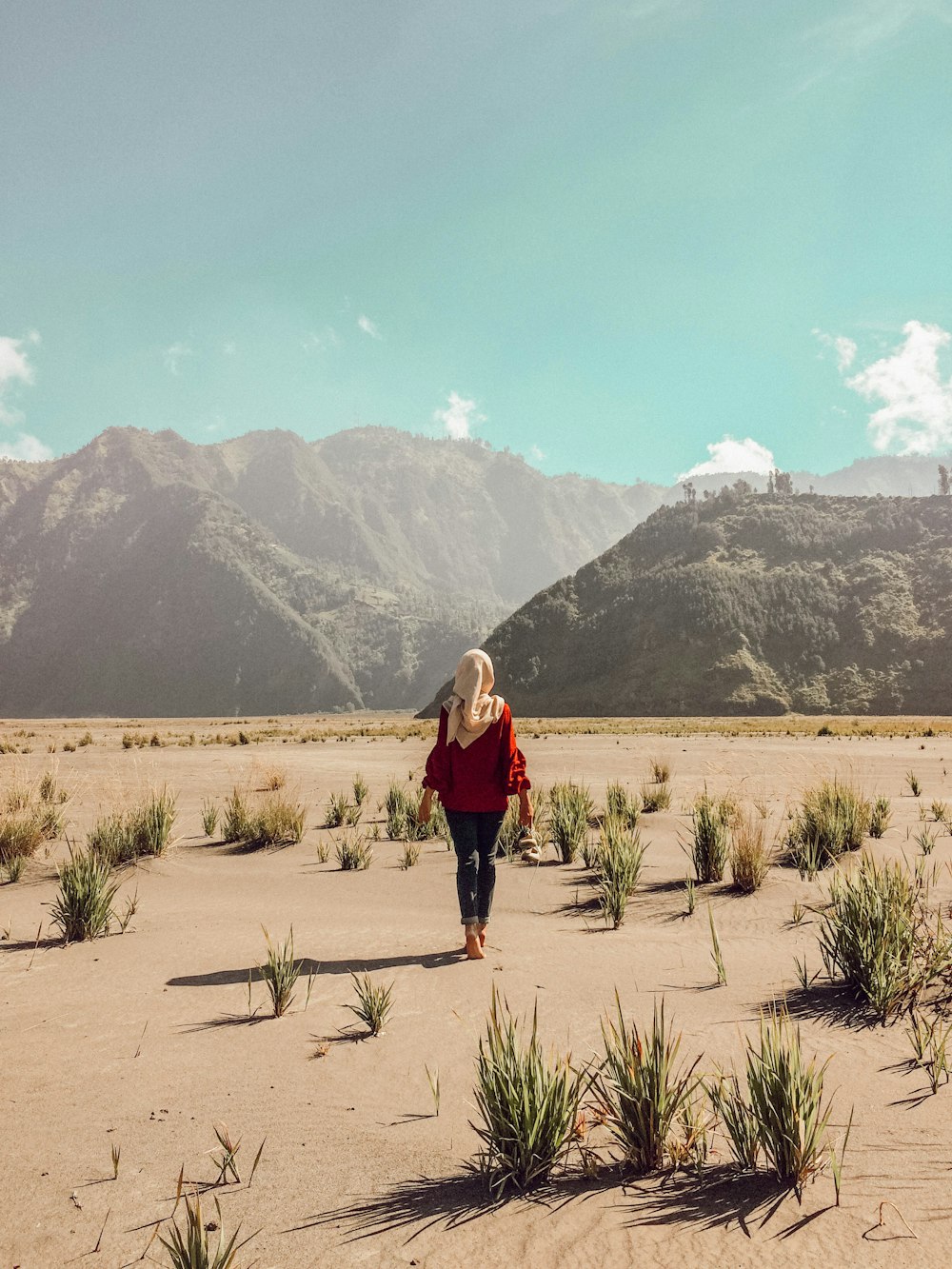 woman walking on desert during daytime