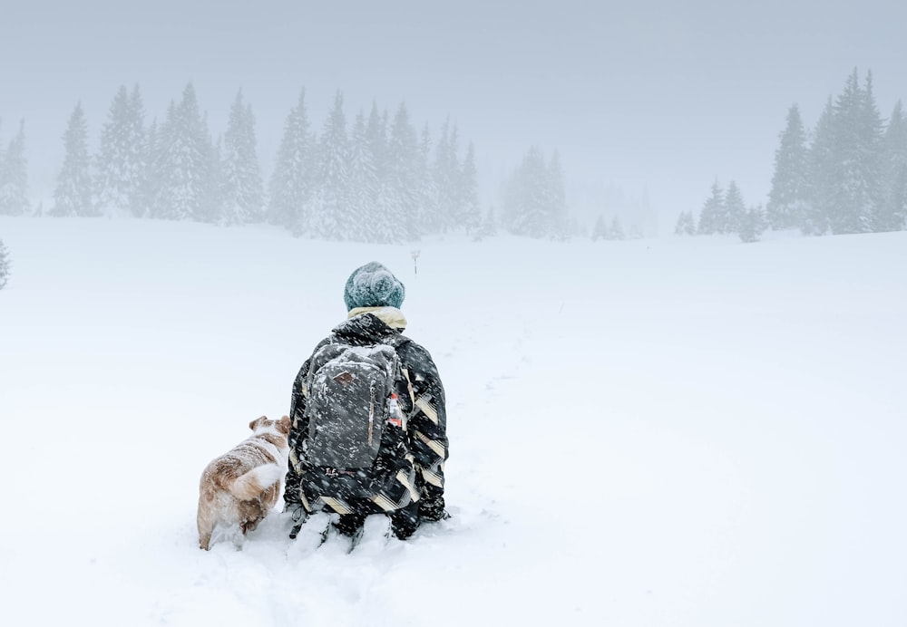 person kneeling on snow capped ground