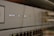 A close-up view of a network switch featuring a row of numbered indicator lights with some illuminated in white and green. The device has multiple Ethernet ports, and connectors are visible in the blurred background.