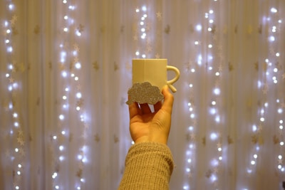 A custom tumbler with elegant vinyl lettering resting beside a glitter mug.