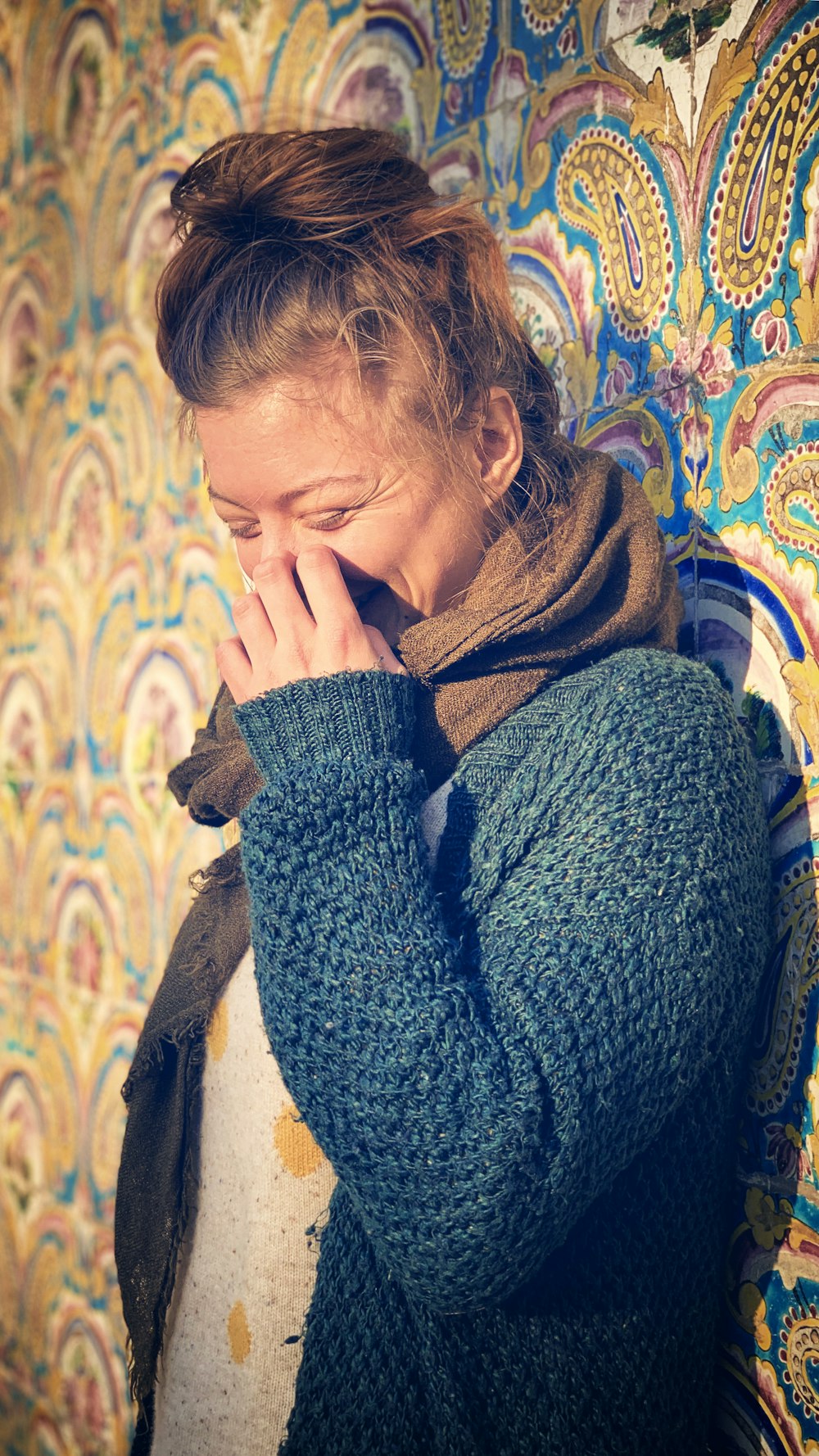 woman standing and smiling while touching nose