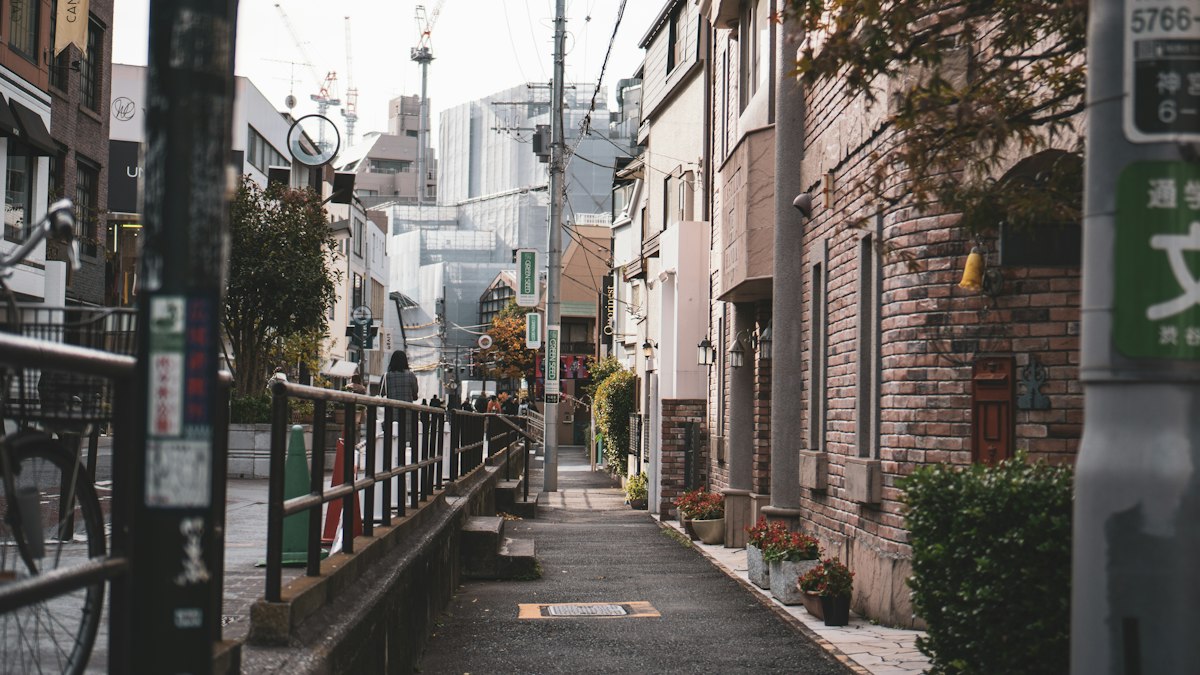 東京の街なかにあるレンガ張りの建物と狭い歩道