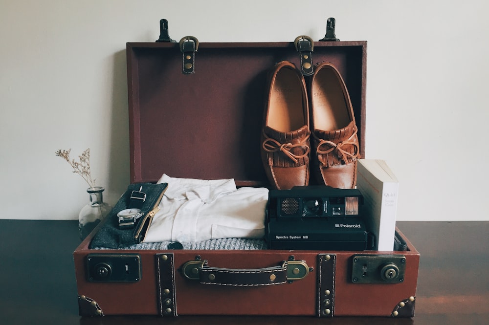 boat shoes inside brown wooden suitcase