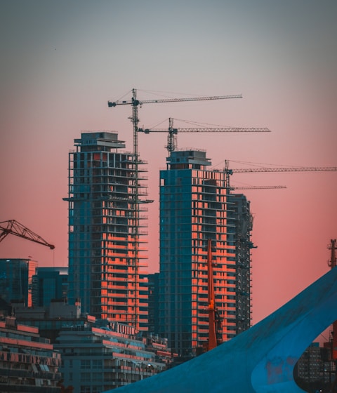 gray building crane photo during sunset