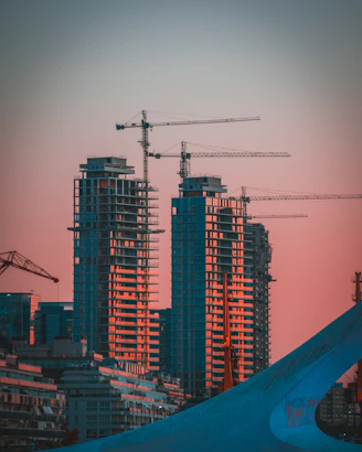 gray building crane photo during sunset