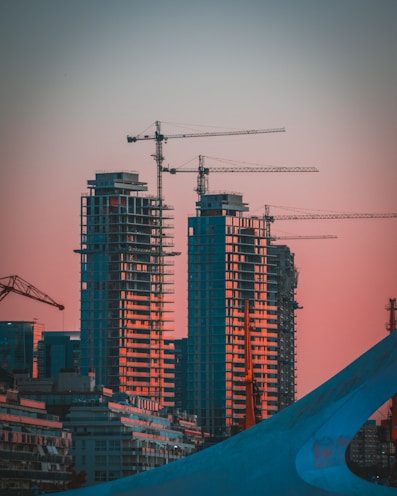 gray building crane photo during sunset