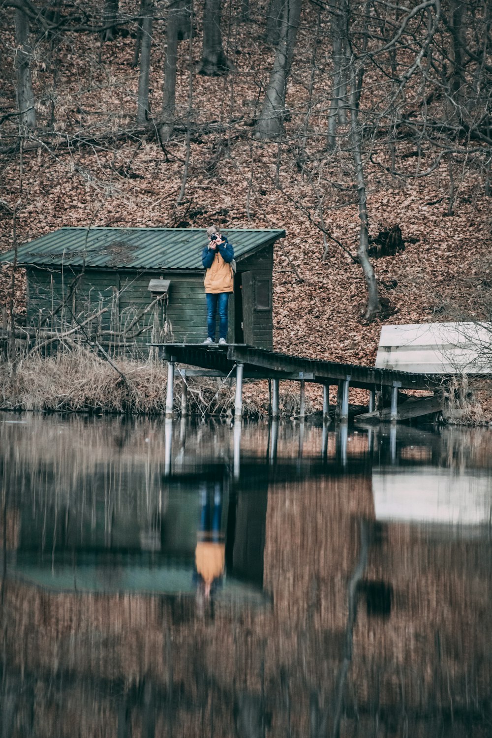 person wearing orange shirt standing on the ocean dock