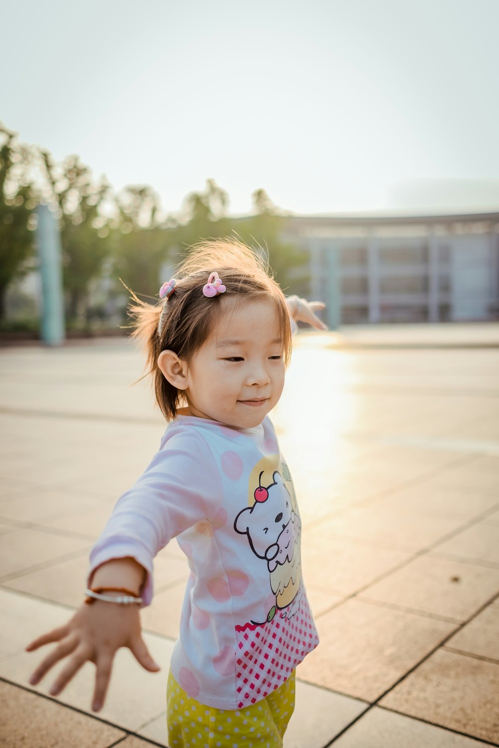 girl wearing white and pink bear graphic long-sleeved shirt outdoor