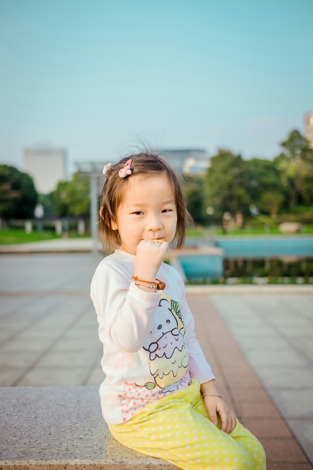 girl sitting while biting her right hand